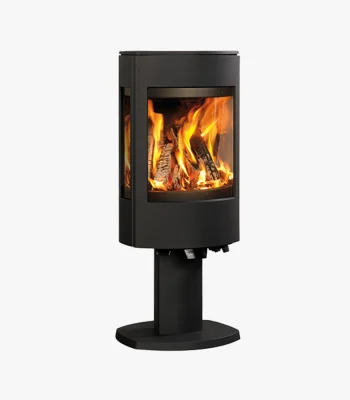 En modern svart vedeldad kamin med glaspaneler som visar en ljus eld inuti, monterad på en piedestal, mot en vit bakgrund.