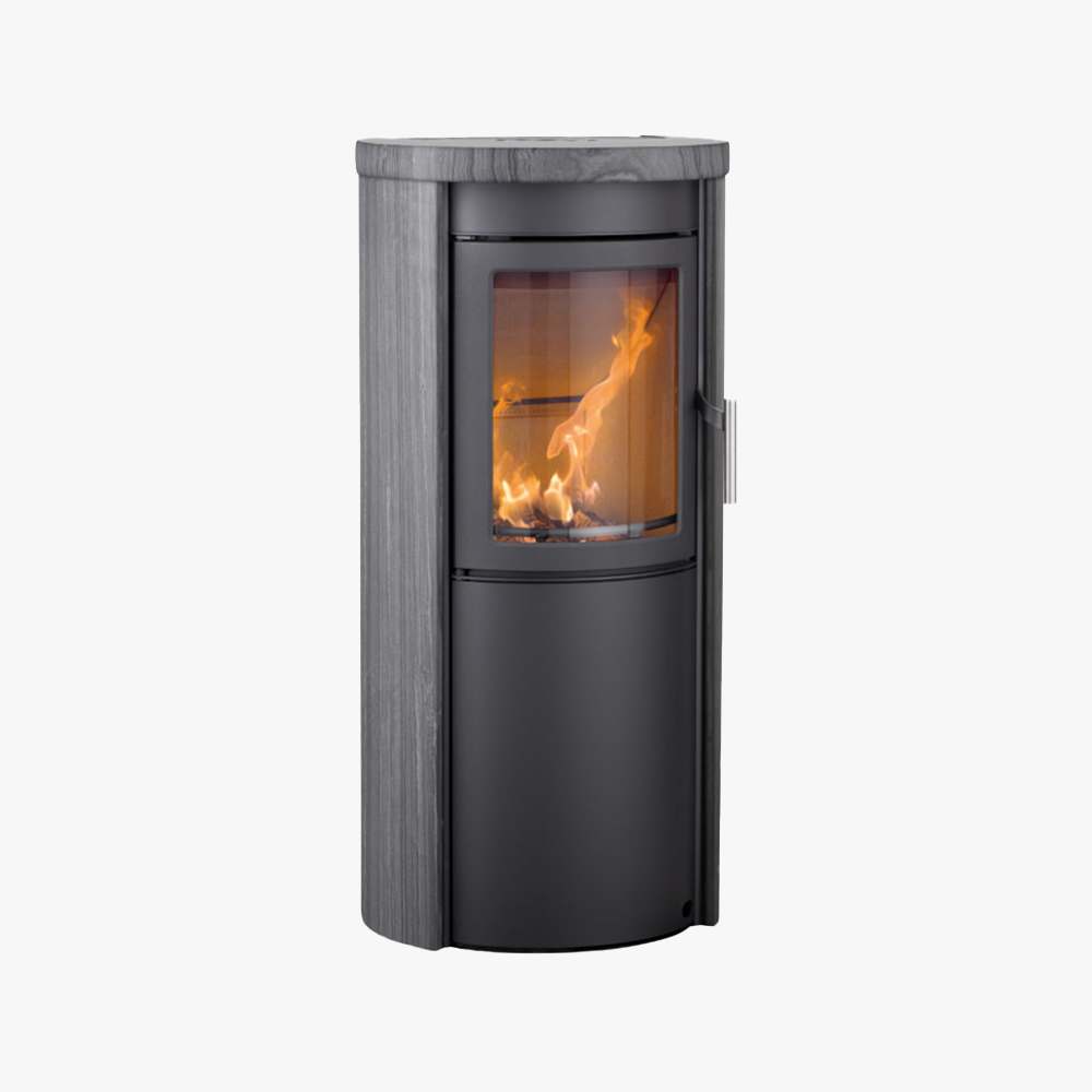 Heta Scan-Line 510 Blackwood är en modern fristående braskamin med en böjd glaslucka som visar synliga lågor, med en elegant svart metallstomme och en slät, ljusgrå stentopp.