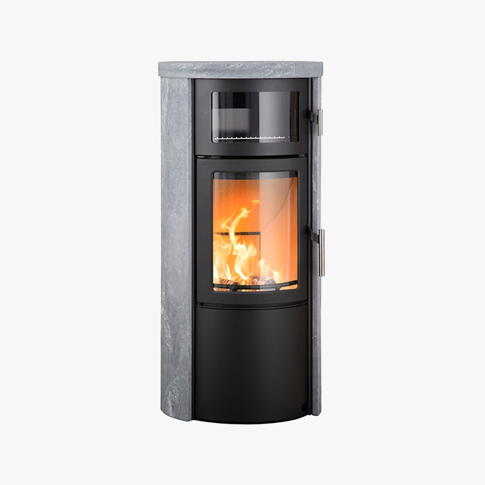 Heta Scan-Line 520B Bakugn Täljsten är en modern, cylindrisk fristående braskamin med en glasdörr som visar elden och har en täljstensfinish på toppen och sidorna.