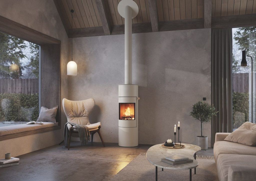 Ett modernt vardagsrum med stora fönster, en mysig fåtölj och en vit vedeldad kamin med synlig eld. Här finns ett soffbord i marmor med levande ljus och en soffa. Rummet har trätak och neutral inredning.